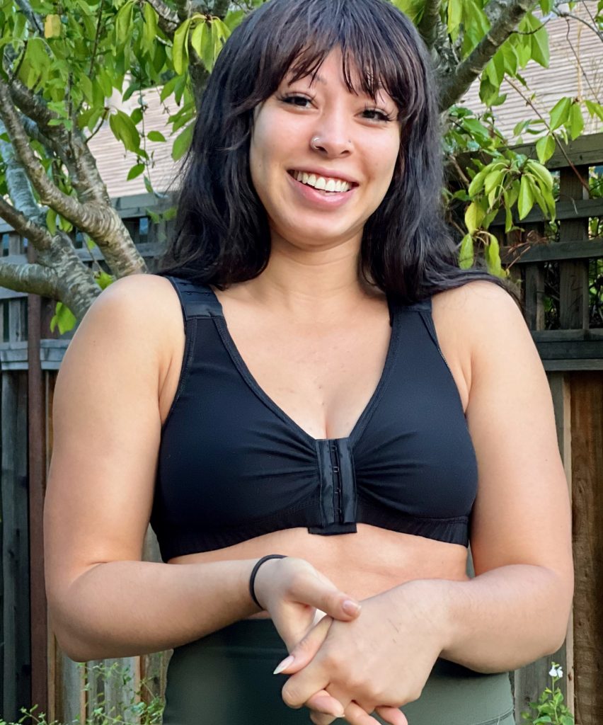 A smiling woman wearing BraLisa's seamless, wireless, organic cotton bra with front closure and adjustable straps; for breast surgery recovery and women seeking a true comfort bra.