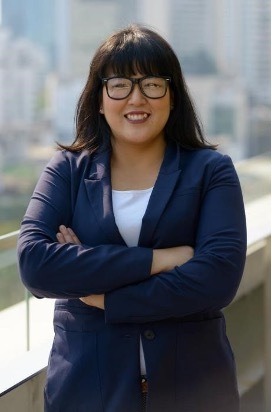 A woman with her arms crossed looking confident and body positive.